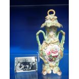 A 19TH CENTURY CONTINENTAL LIDDED VASE, with green vine leaf decoration and hand painted floral pane