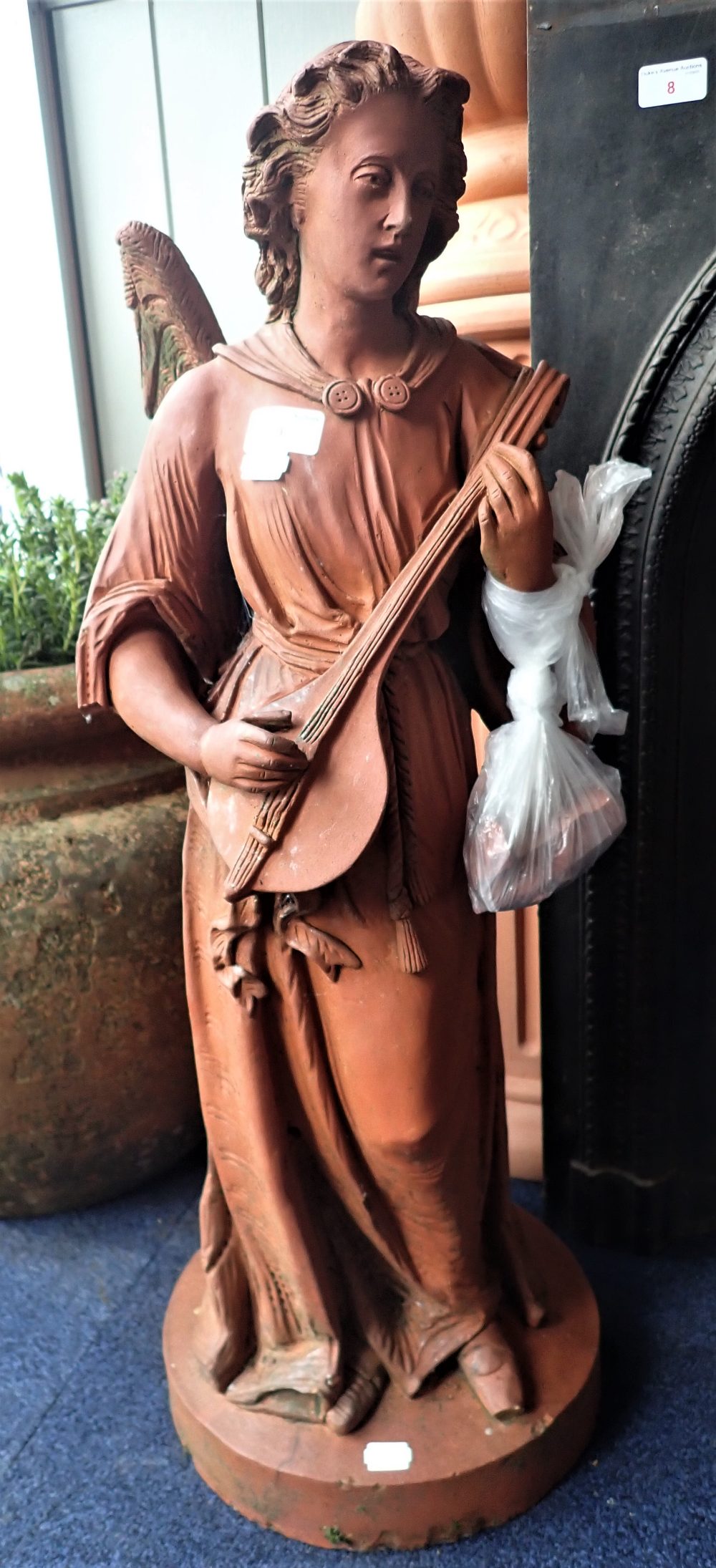 A MOULDED TERRACOTTA FIGURE OF AN ANGEL PLAYING A LUTE, 79cm high
