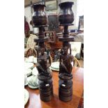 A LARGE PAIR OF AFRICAN WOODEN CANDLESTICKS carved with tribal figures, 67cm high