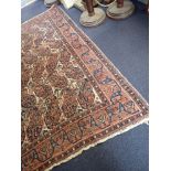 A PERSIAN STYLE WOVEN WOOL RUG, RED AND BLUE MOTIFS ON WHITE GROUND WITHIN BORDERS, 219CM LONG, 168C