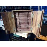 A HAND-MADE WALNUT COIN COLLECTOR'S CABINET with 18 fitted trays and a deeper drawer, all enclosed b