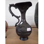 A RELIEF CAST AND PATINATED METAL EWER IN ORIENTAL STYLE, WITH DRAGON HANDLE, 31CM HIGH