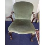 A CARVED WALNUT AND GREEN VELVET UPHOLSTERED ELBOW CHAIR IN GEORGE II STYLE, circa 1900, the arched