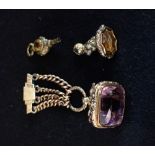 A 9CT YELLOW GOLD CAST SEAL WITH AMETHYST MATRIX, suspended from a four chain curb-link brooch fob,