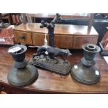 A 19TH CENTURY CAST IRON STUDY OF A HUNTING DOG and a pair of squat candlesticks