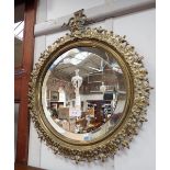 A CAST BRASS FRAMED CIRCULAR MIRROR decorated with a grotesque head, with bevelled plate, 43cms wide