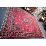A LARGE RED GROUND PERSIAN DESIGN RUG 285cm x 310cm