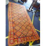 A MORROCCAN RUG IN BRIGHT COLOURS on an orange ground 135cm x 290cm