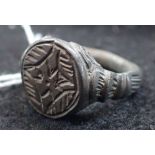 A MEDIEVAL, PROBABLY TUDOR, CAST METAL RING with stylised cross, size R.