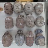 A LARGE COLLECTION OF PAINTED TERRACOTTA HEADS