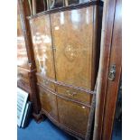 A REPRODUCTION WALNUT AND MARQUETRY BOW FRONT DRINKS CABINET