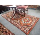 AN ORANGE GROUND AFGHAN RUG