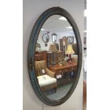 A PAINTED WOOD AND COMPOSITION FRAMED OVAL WALL MIRROR,