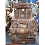 A COLLECTION OF VINTAGE LEATHER SUITCASES and other luggage, all with shipping labels (6)