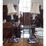 A PAIR OF SILVER PLATED CANDLESTICKS converted to electricity, 32cms high plus fittings