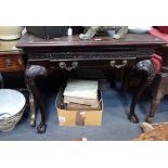 A CHIPPENDALE STYLE WRITING TABLE, the legs with claw and ball feet with Greek key blind fret frieze