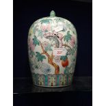 A CHINESE POT AND COVER decorated with fruit, 27cm high (overall)