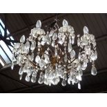 A GILT METAL EIGHT BRANCH CHANDELIER with prismatic glass drops, 47cms high, 65cms dia.