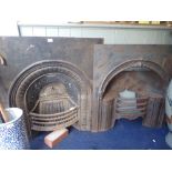 AN EARLY VICTORIAN CAST IRON FIREPLACE INSERT with hob grate within an arch, and another similar (2)