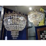 A PAIR OF CUT GLASS BAG CHANDELIERS with brass frames, 33cm dia. x 33cm drop (approx)