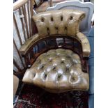 A REPRODUCTION SWIVEL DESK CHAIR with green leather upholstery