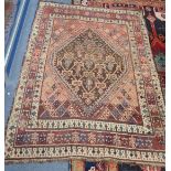 A RED GROUND PERSIAN RUG, 108cms x 149cms (worn and frayed)