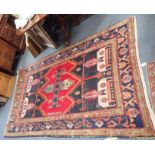 AN AFGHAN TYPE RUG with red central panel with stylised plant and geometric borders