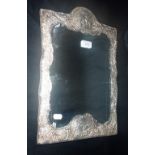 AN EMBOSSED SILVER FRAMED TABLE MIRROR