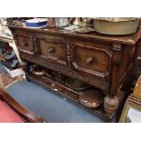 A LARGE REPRODUCTION CARVED OAK SIDEBOARD