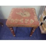 A 19TH CENTURY MAHOGANY STOOL on turned legs with a needlework top