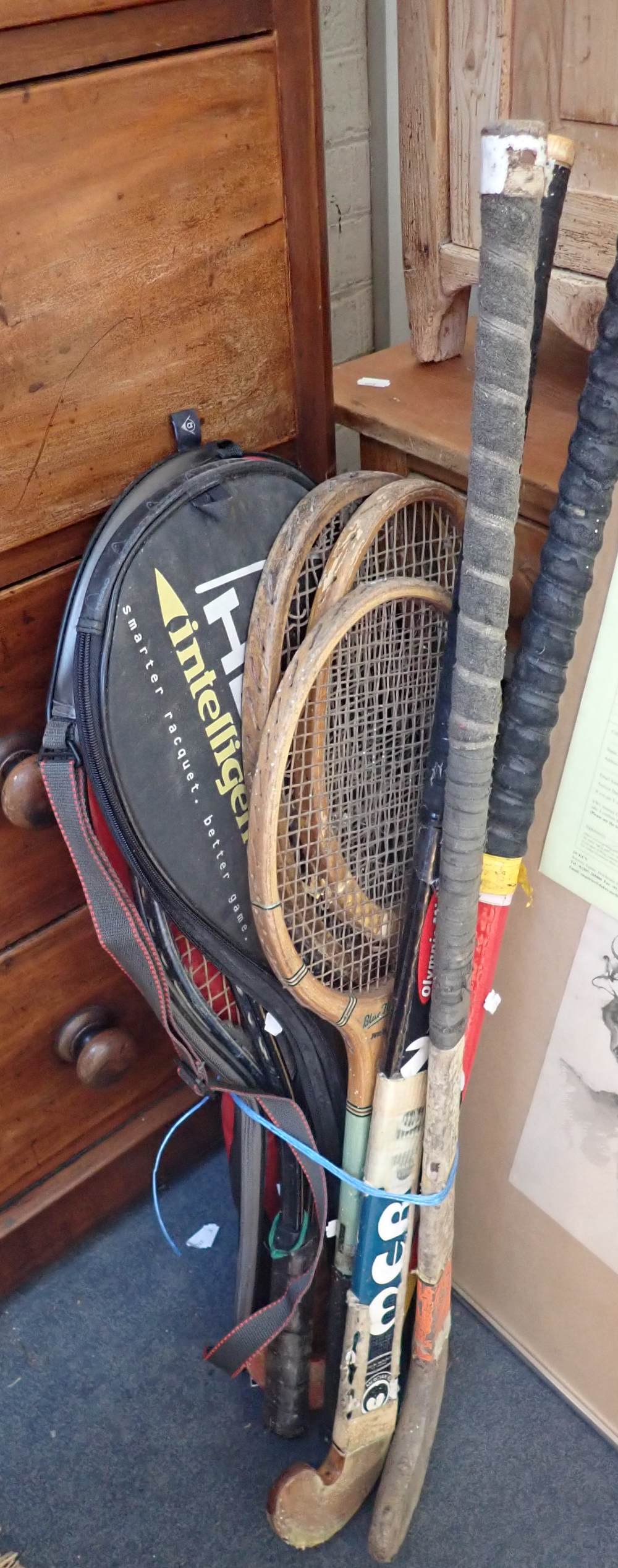 A COLLECTION OF TENNIS RACQUETS AND HOCKEY STICKS