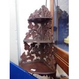 A BLACK FOREST STYLE THREE TIER CORNER SHELF