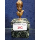 A FRENCH MINIATURE BUST OF A CHILD, on a green marble base, 11cm high