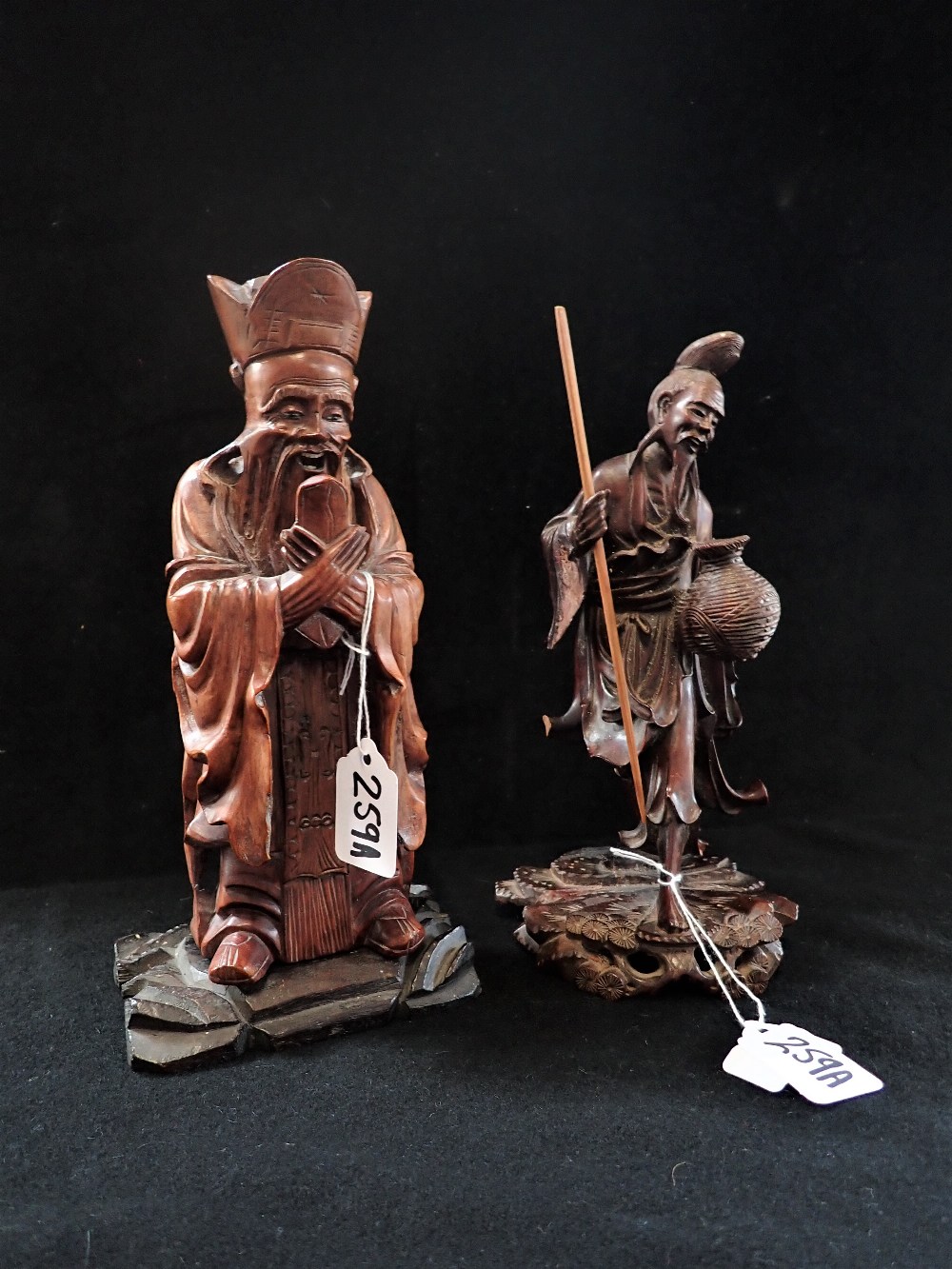 A JAPANESE CARVED WOODEN STUDY OF A MAN WITH A POT, 25cm high and a similar carving (2)