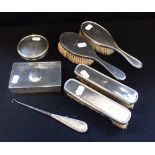 A SILVER BACKED DRESSING TABLE SET, comprising four brushes, button hook, container and lid