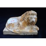 A 19TH CENTURY GLAZED POTTERY STUDY OF A LION, 14cm long