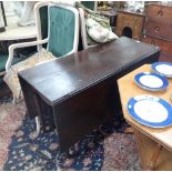 A GEORGE II OAK DROP FLAP TABLE (fitted later castors)