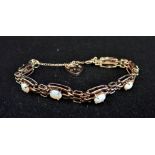 A 9CT GOLD OPAL GATE-LINK BRACELET, seven links set with an oval-cut opal, with padlock clasp and sa