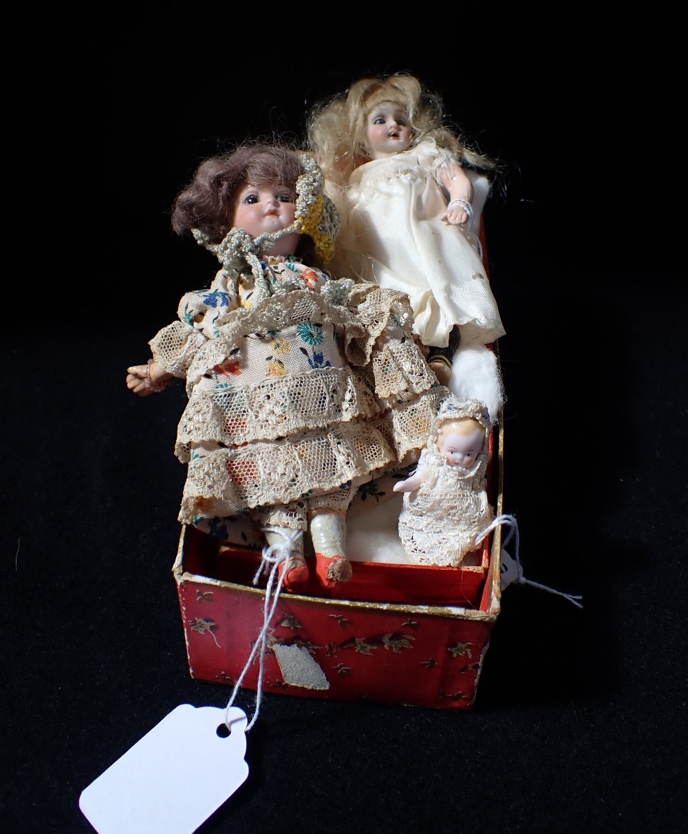 A MINIATURE EDWARDIAN BISQUE HEADED DOLL 14cm high and two similar