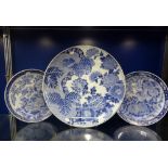 A LARGE ORIENTAL BLUE AND WHITE CHARGER, 47cm dia. and a pair of similar plates, 31.5cm dia. (3)