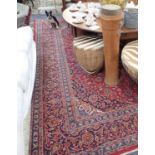 A LARGE RED GROUND PERSIAN DESIGN CARPET