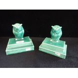 A PAIR OF GREEN ART DECO CERAMIC BOOKENDS