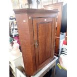 A GEORGE III OAK HANGING CORNER CUPBOARD