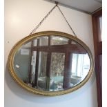 AN EDWARDIAN OVAL GILT FRAMED MIRROR