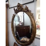 A VICTORIAN OVAL GILT FRAMED WALL MIRRO