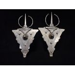 A PAIR OF WHITE METAL ADORNMENTS