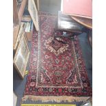 A RED GROUND PERSIAN DESIGN RUG