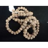 A STRING OF INDIAN 'NUT' BEADS, approx 180 cm long