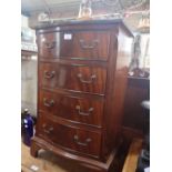 A REPRODUCTION MAHOGANY SERPENTINE BEDSIDE CHEST