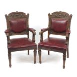 Pair of carved walnut elbow chairs with red upholstered back, seat and elbow pads, each 107cm high :